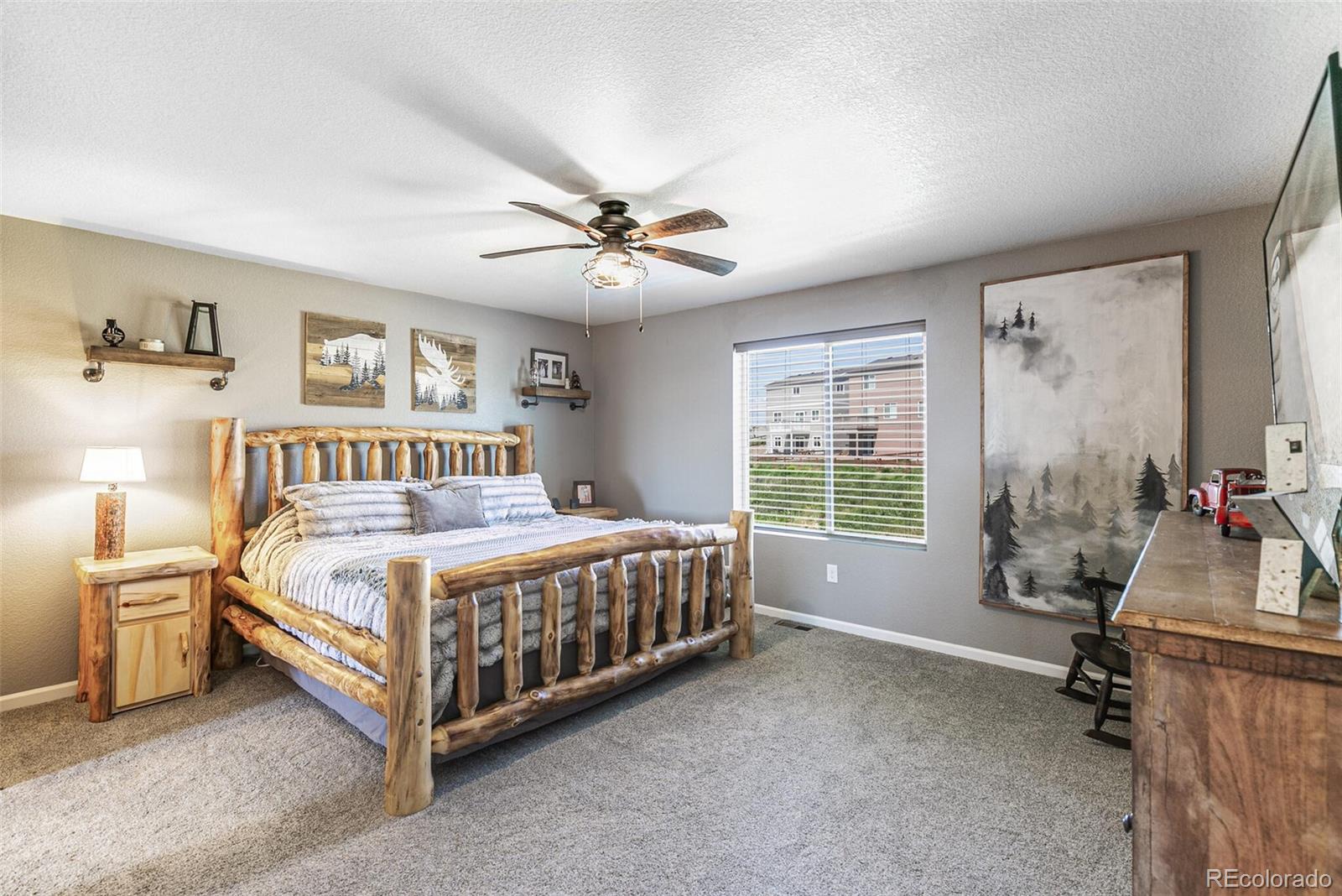42891 Hawktree Circle Elizabeth, CO 80107 - Photo 19 of 39 a bedroom with a large bed and a chandelier
