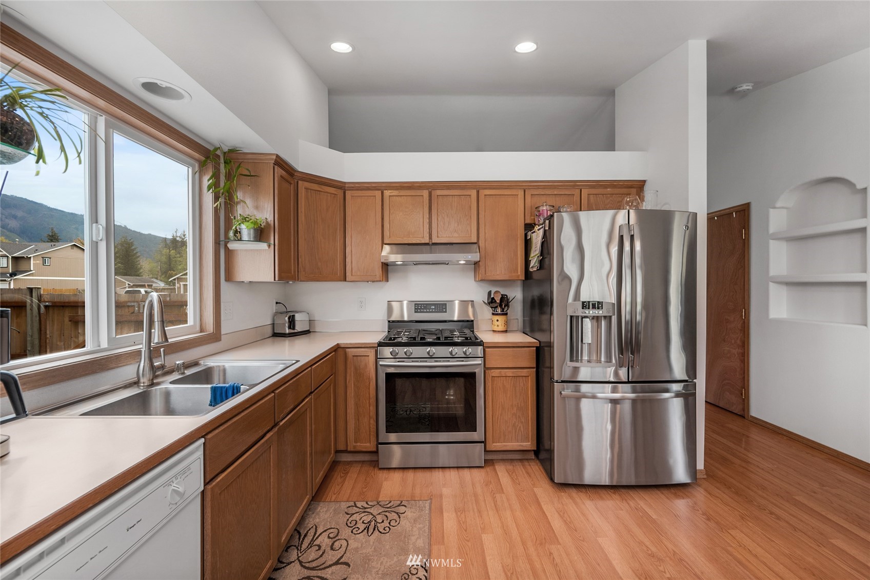 234 17th Street Gold Bar, WA 98251 - Photo 2 of 25 a kitchen with stainless steel appliances granite countertop a refrigerator a sink dishwasher a stove and a refrigerator with wooden floor