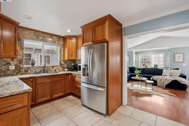 a kitchen with granite countertop a stove chairs sink and cabinets