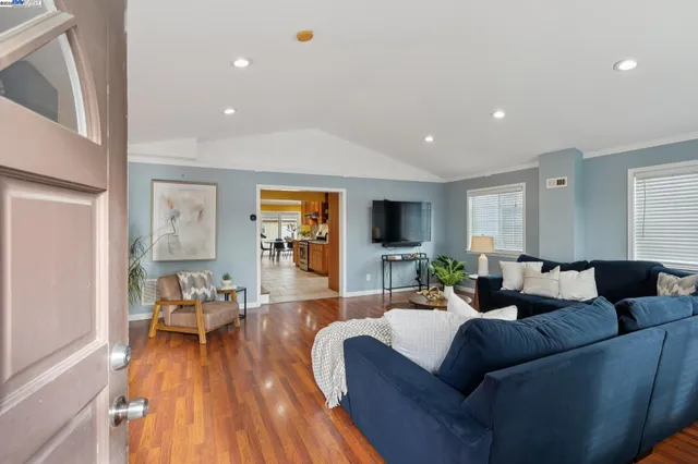 a living room with furniture and a wooden floor