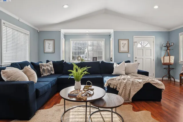 a living room with furniture and wooden floor