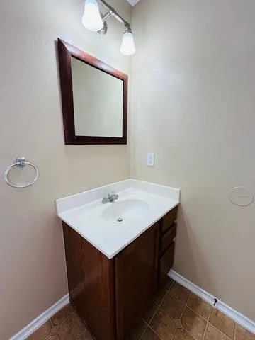 a bathroom with a sink vanity and mirror