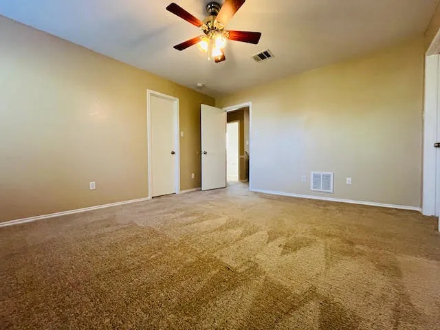 a view of a big room with a ceiling fan and a window