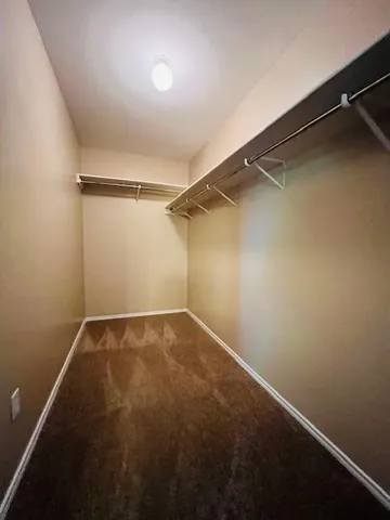 an empty room with a walk in closet and a window