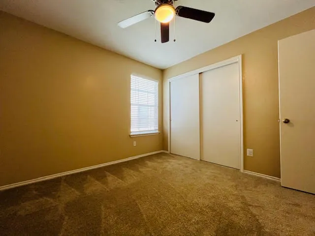 an empty room with windows and fan