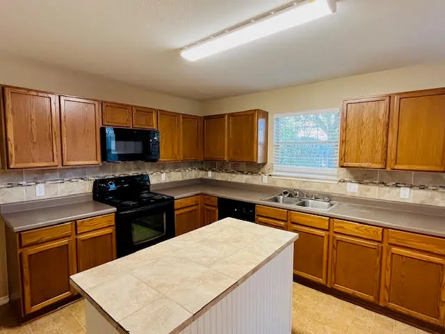 a kitchen with sink a microwave and cabinets