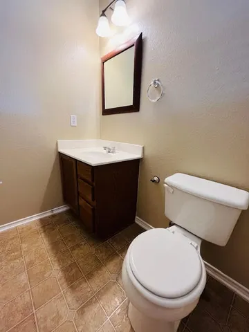 a bathroom with a toilet sink and mirror