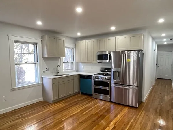 a kitchen with granite countertop stainless steel appliances a refrigerator sink and microwave