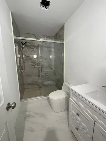 a bathroom with a shower a toilet and a sink