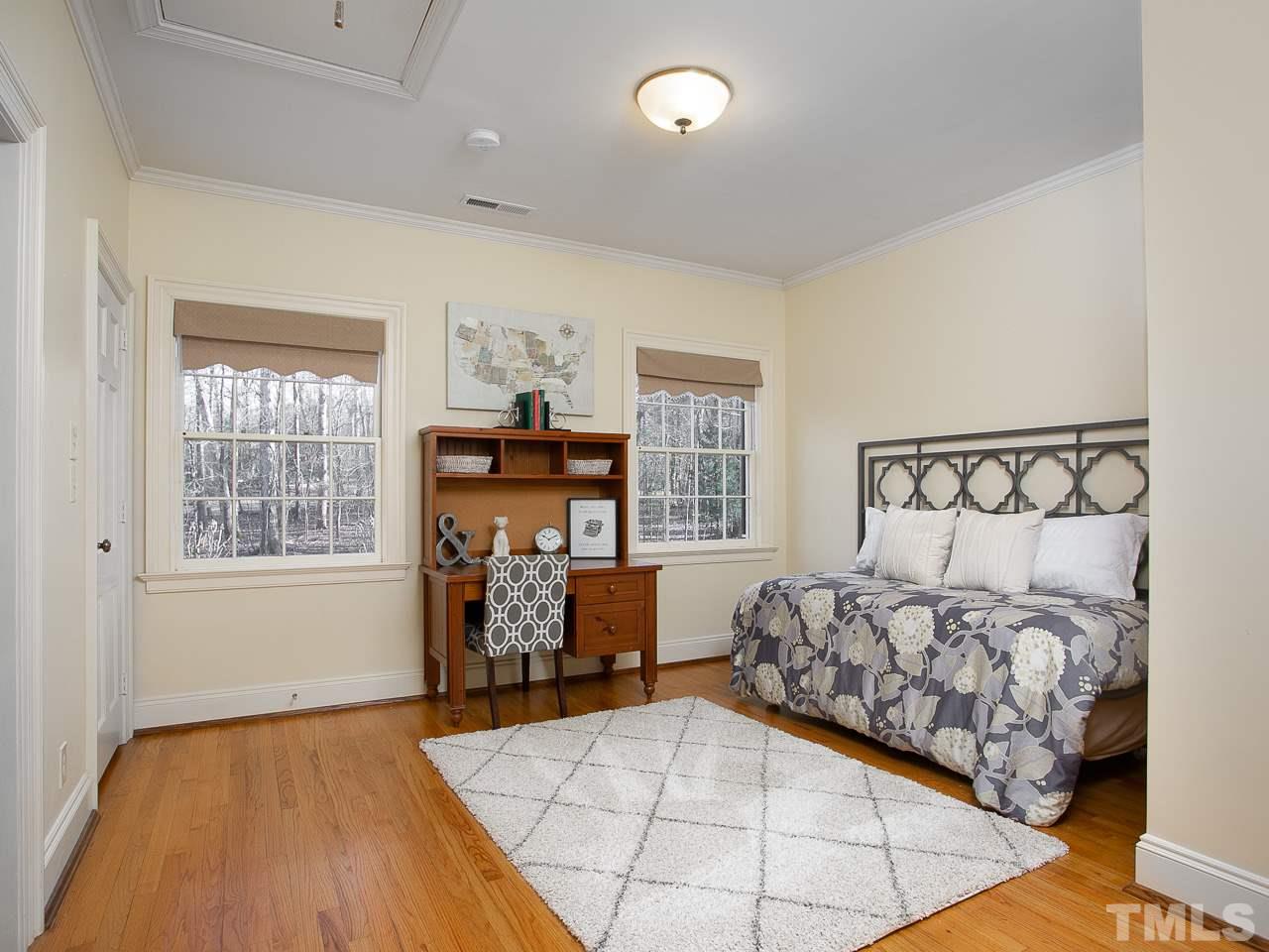 1528 Pinecrest Road Durham, NC 27705 - Photo 24 of 30 a bedroom with a bed and wooden floor