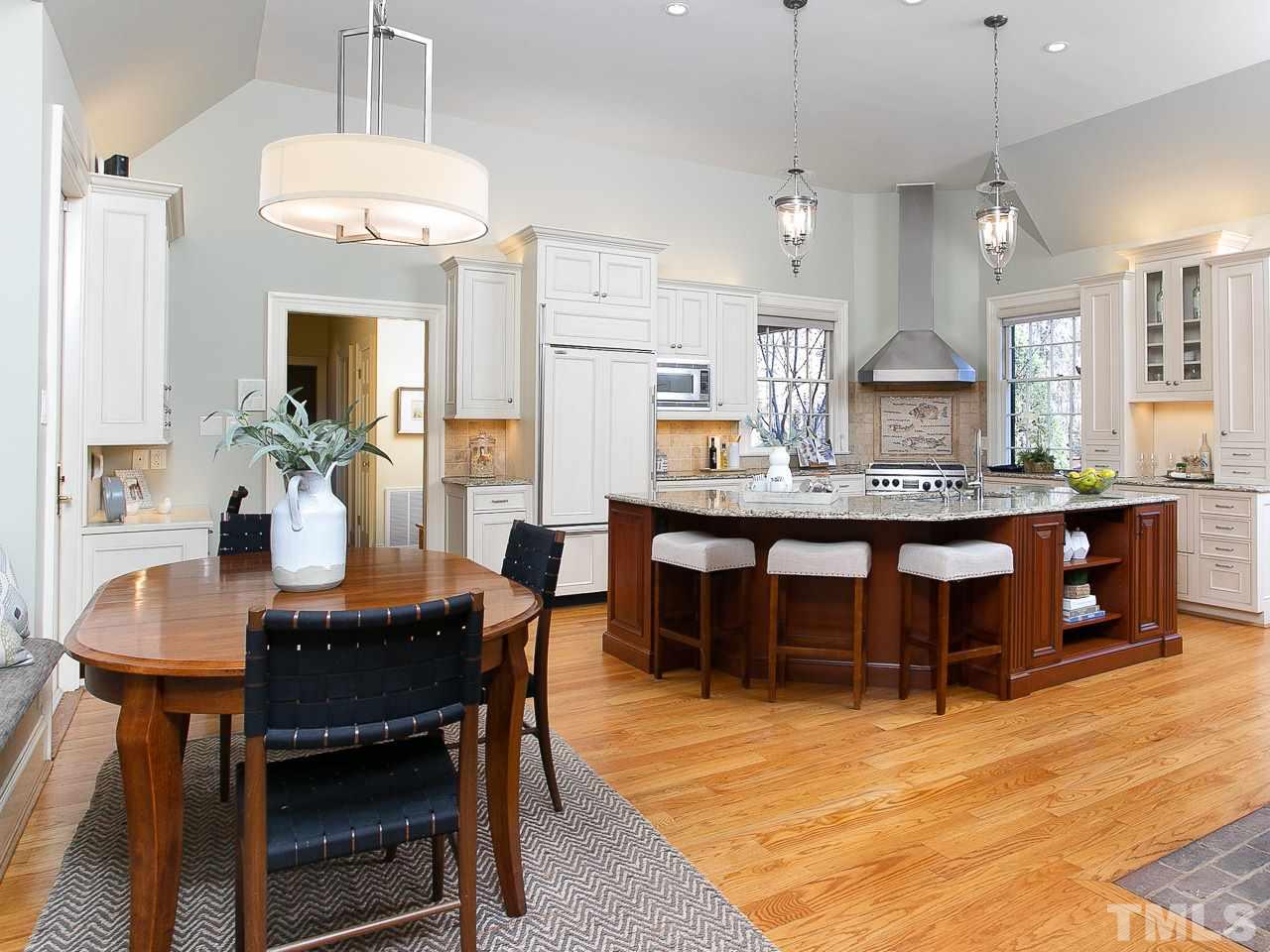 1528 Pinecrest Road Durham, NC 27705 - Photo 6 of 30 a dining table with wooden floor and kitchen view