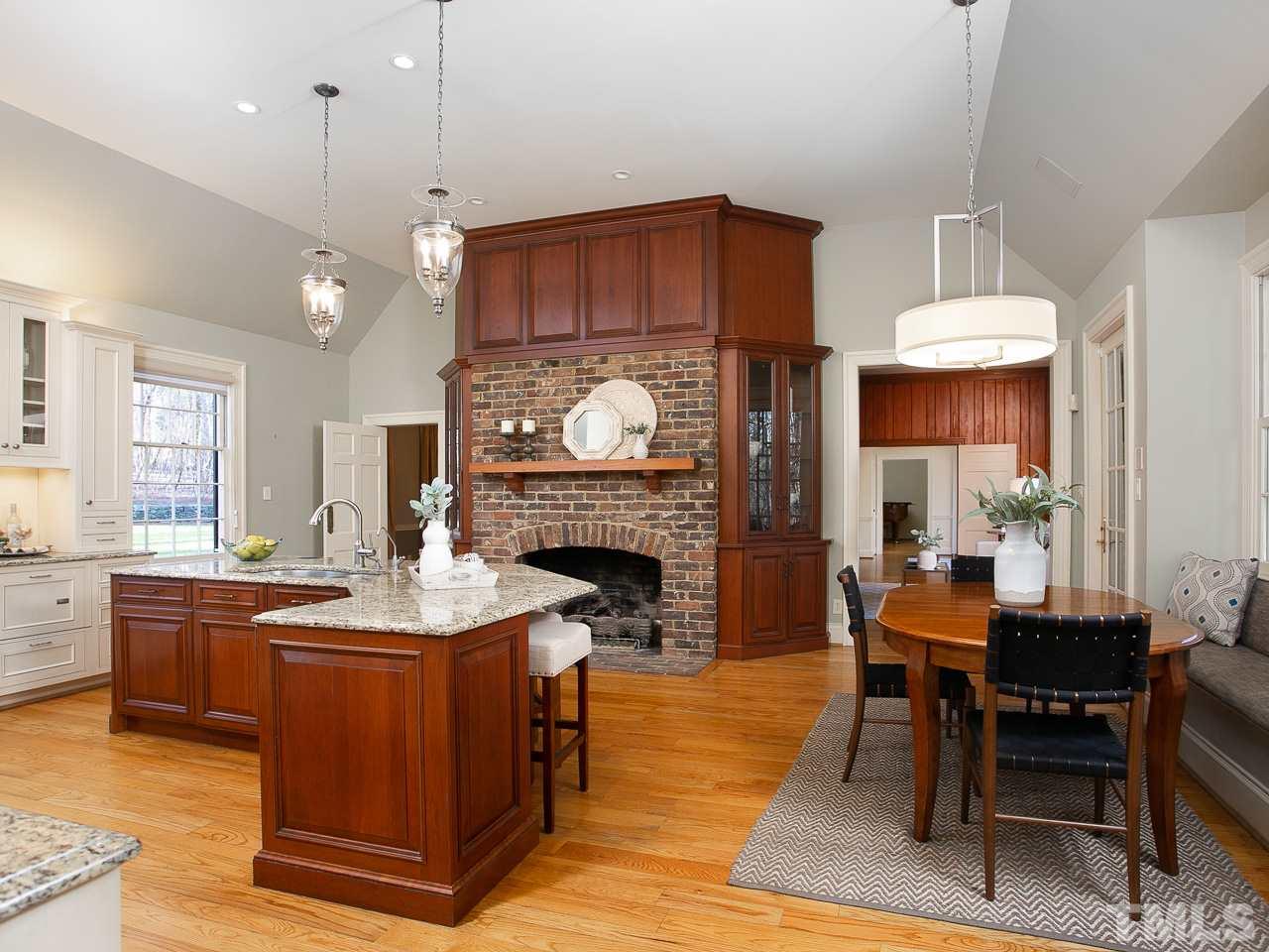 1528 Pinecrest Road Durham, NC 27705 - Photo 7 of 30 a open kitchen with stainless steel appliances granite countertop a stove a refrigerator a oven a sink a dining table and chairs with wooden floor
