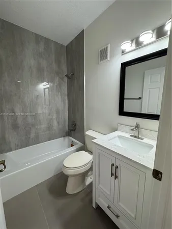 a bathroom with a granite countertop sink mirror and a shower