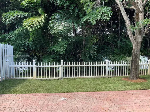a front view of a house with garden and trees