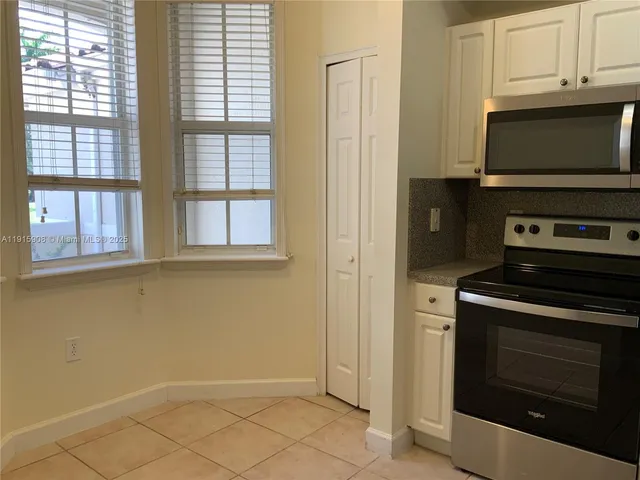 a kitchen with stainless steel appliances granite countertop white cabinets and a stove