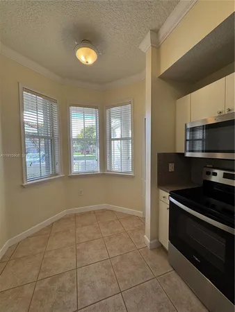 a kitchen with granite countertop a stove a sink and a microwave