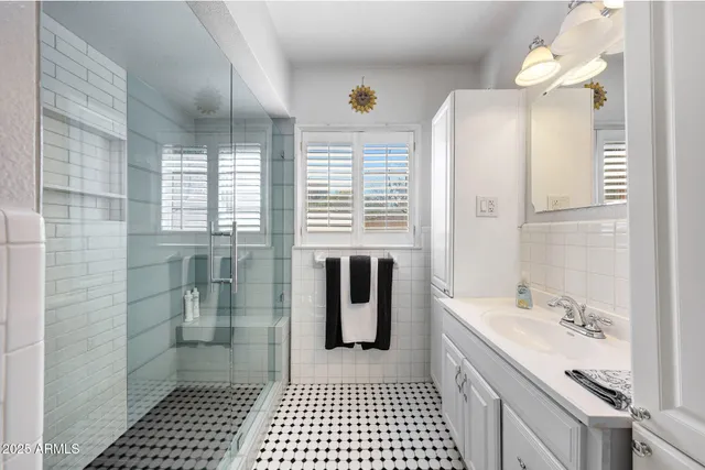 a bathroom with a sink a mirror and a shower