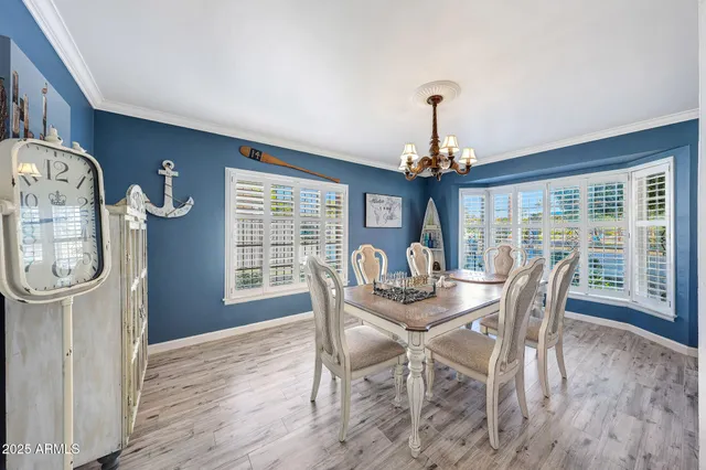 a dining room with furniture a chandelier and wooden floor