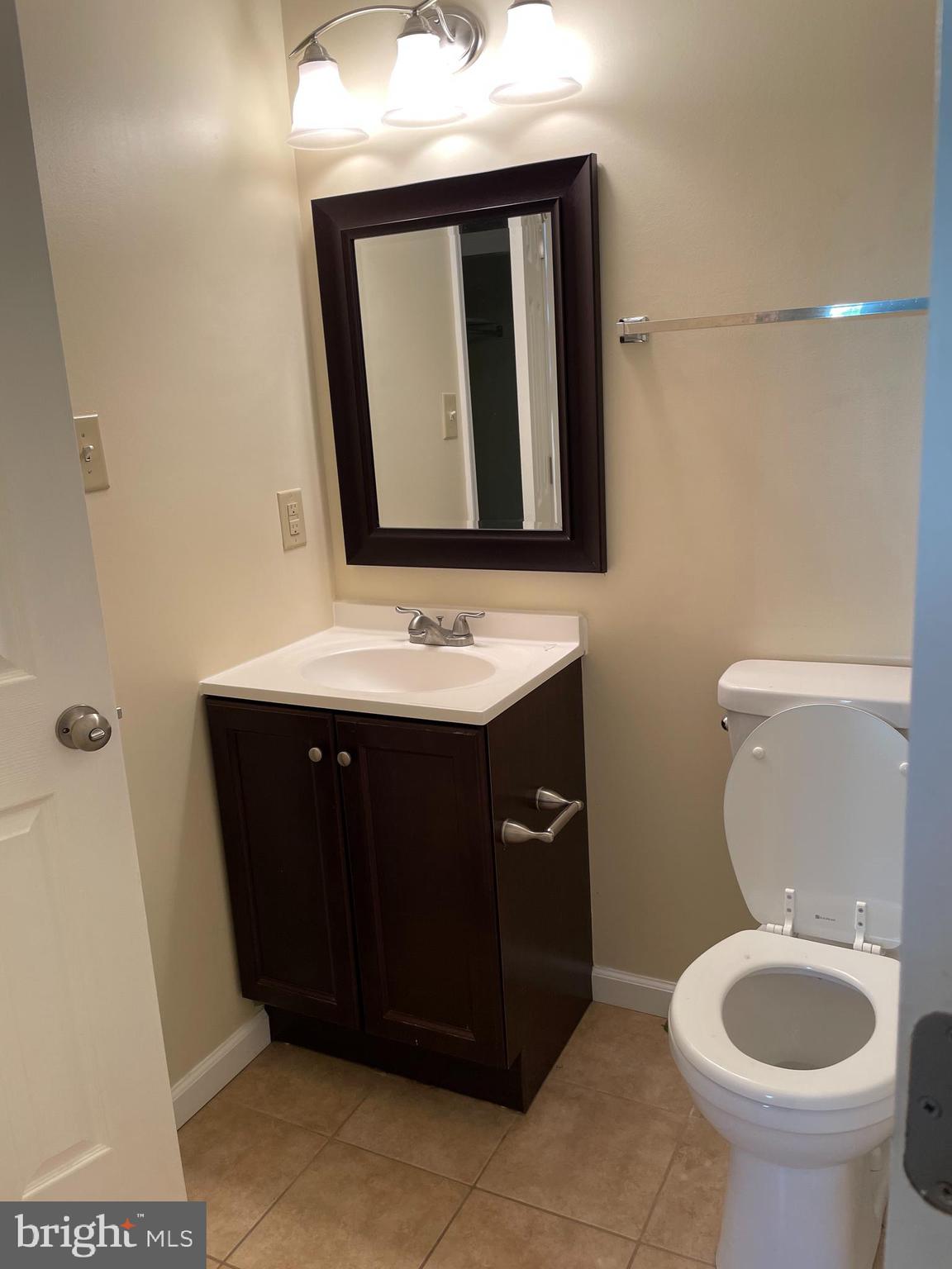 12405 Gooderham Way Gaithersburg, MD 20878 - Photo 22 of 31 a bathroom with a toilet sink vanity and mirror