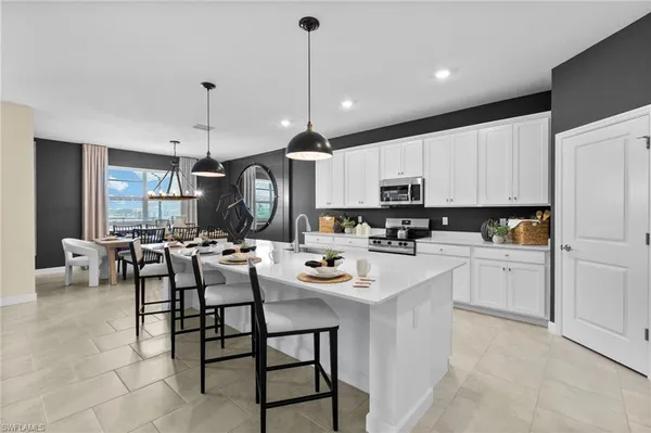a kitchen with counter space appliances and chairs