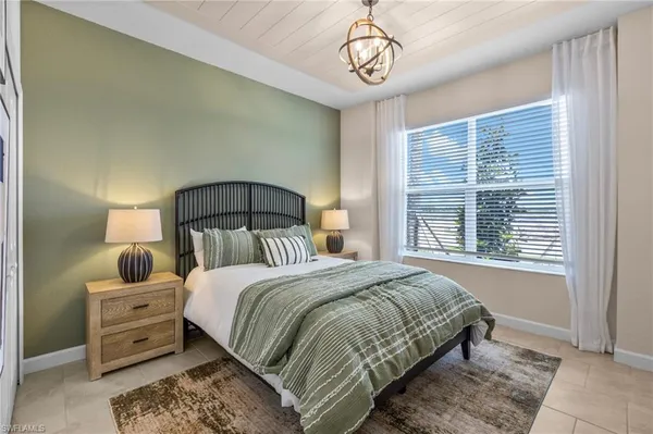 a bedroom with a large bed and a chandelier