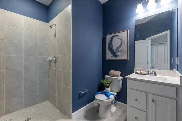 a bathroom with a toilet sink vanity and mirror