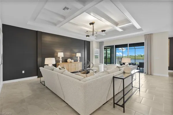 a room with stainless steel appliances kitchen island granite countertop a sink and a refrigerator