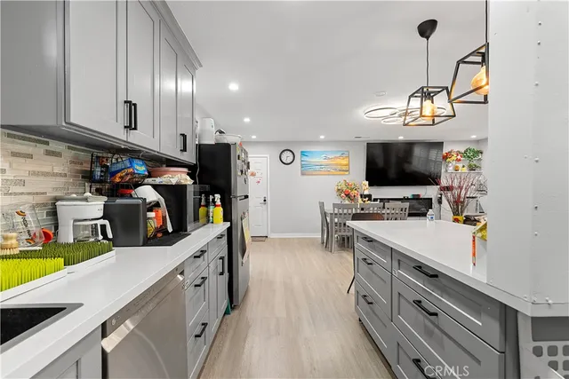 a kitchen that has a lot of cabinets and wooden floor
