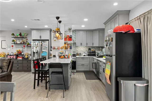 a kitchen with stainless steel appliances kitchen island granite countertop a refrigerator and microwave