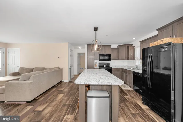a large kitchen with a center island wooden floor and a counter top space