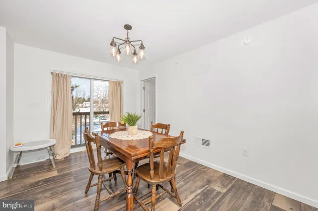 a view of a dining room with furniture a chandelier and wooden floor