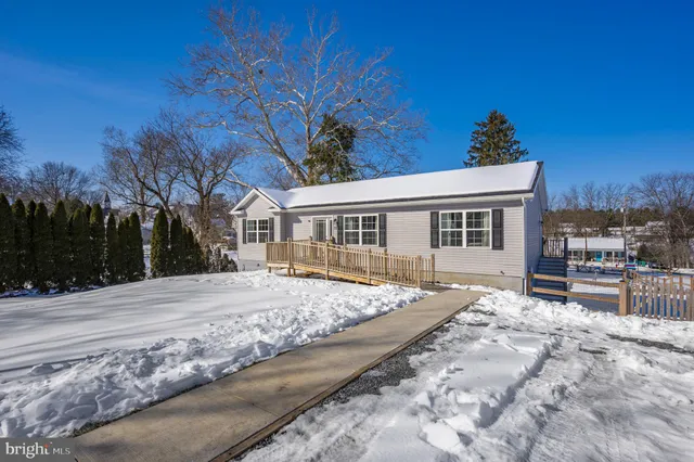 a front view of house with yard and trees in the background
