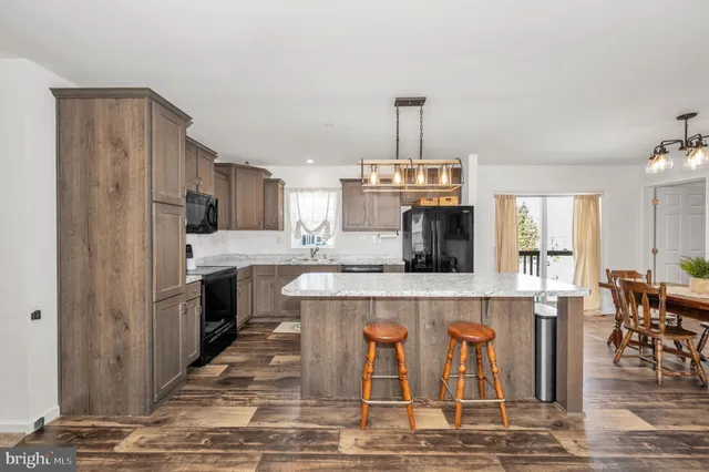 a open kitchen with stainless steel appliances granite countertop a stove and refrigerator