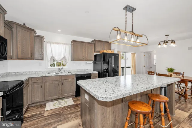 a kitchen with stainless steel appliances kitchen island granite countertop a kitchen island a stove a table and chairs in it