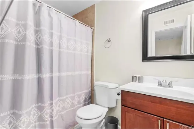 a bathroom with a sink a toilet and shower curtain