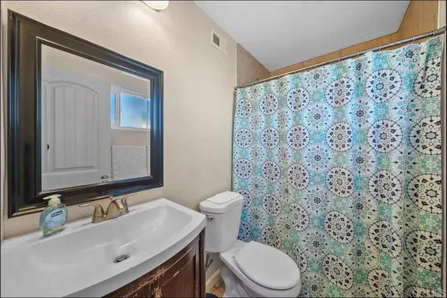 a bathroom with a sink a toilet and a mirror