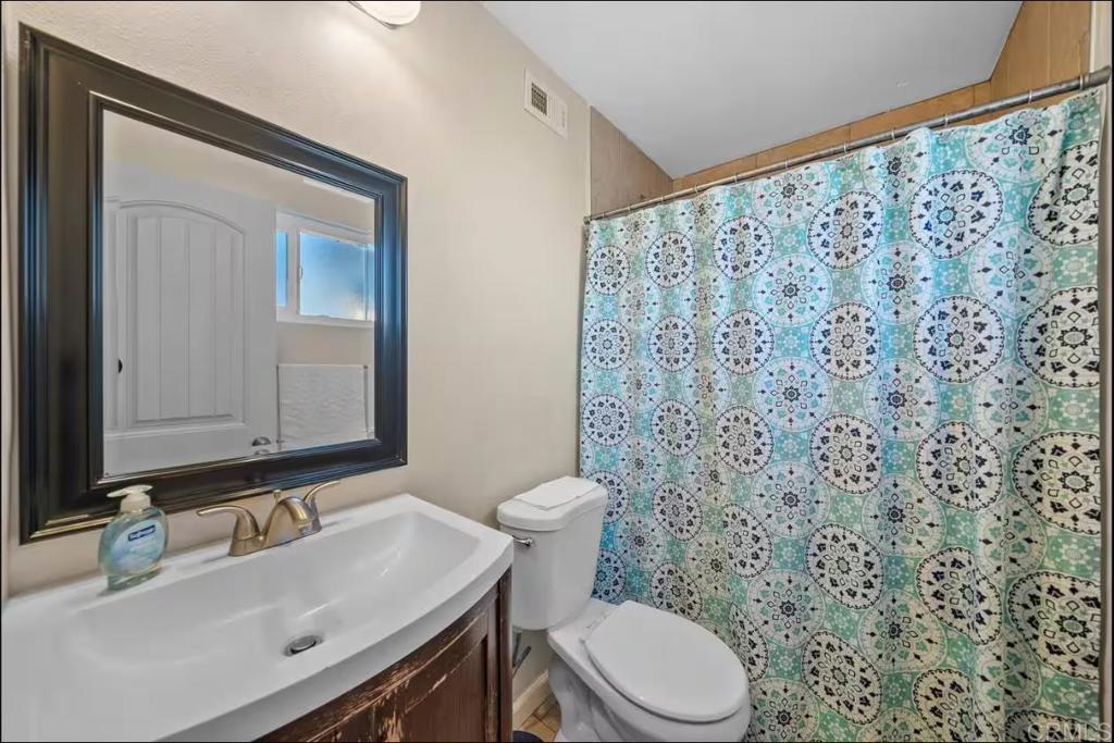 409 Pesca Court Spring Valley, CA 91977 - Photo 28 of 28 a bathroom with a sink a toilet and a mirror