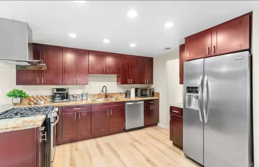 409 Pesca Court Spring Valley, CA 91977 - Photo 9 of 28 a kitchen with granite countertop stainless steel appliances cabinets a sink and a counter top space