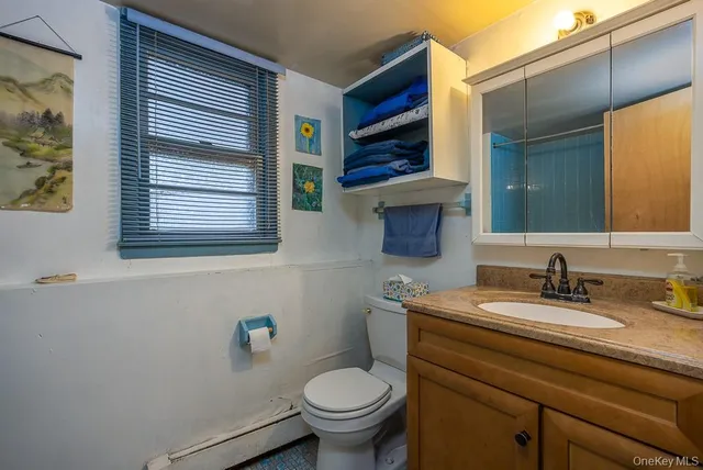 a bathroom with a toilet a sink and mirror