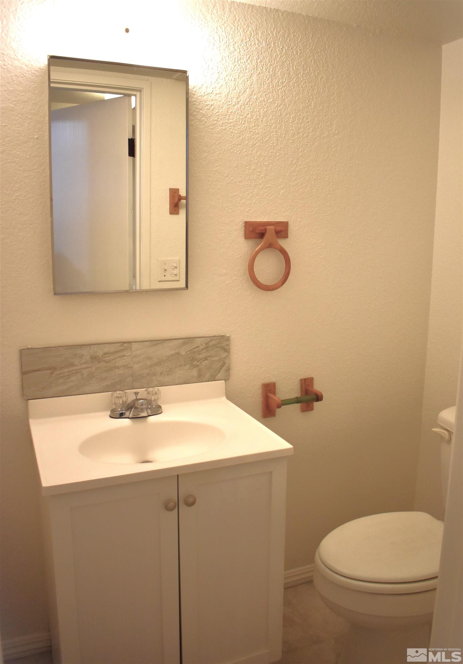 1400 East 9th Street, Unit 8 Reno, NV 89512 - Photo 8 of 16 a bathroom with a toilet sink vanity and mirror