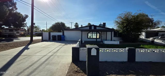 a front view of a house with yard and potted plants