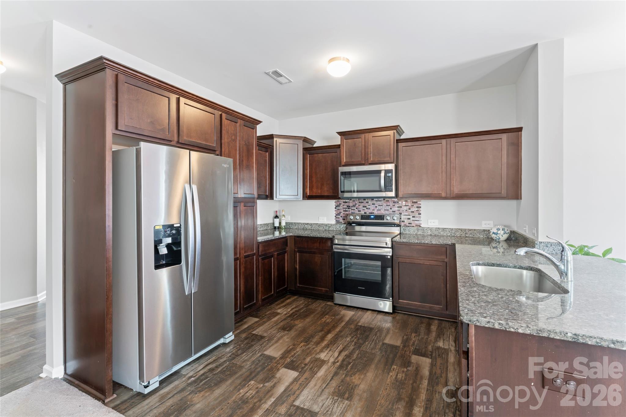 12561 Garron Road Midland, NC 28107 - Photo 11 of 36 a kitchen with granite countertop a refrigerator stove and oven