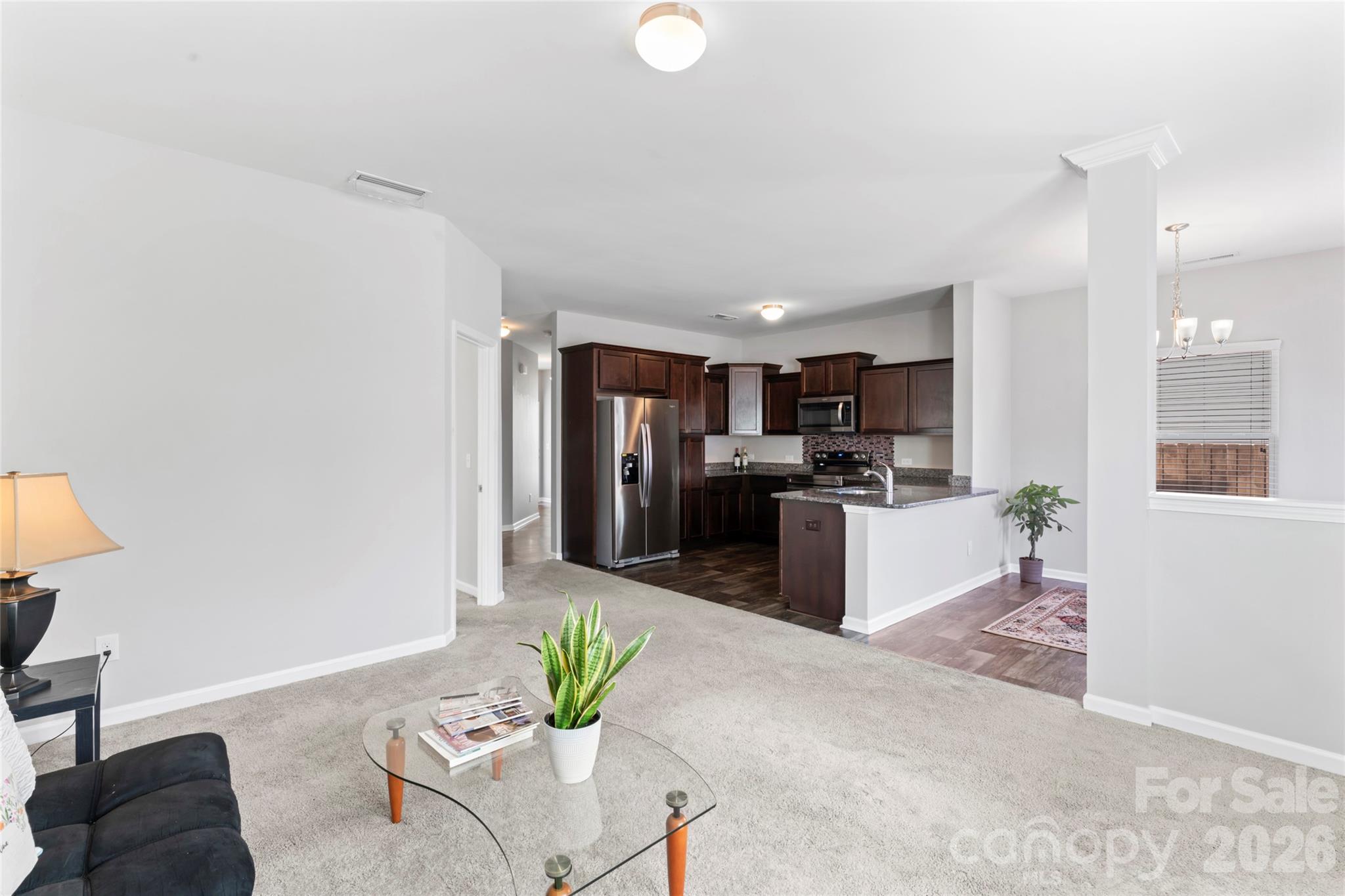 12561 Garron Road Midland, NC 28107 - Photo 13 of 36 a kitchen with stainless steel appliances kitchen island granite countertop a refrigerator a stove a sink a dining table and chairs with wooden floor
