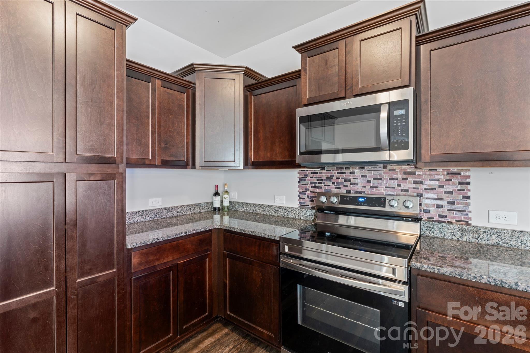12561 Garron Road Midland, NC 28107 - Photo 10 of 36 a kitchen with stainless steel appliances wooden cabinets and a stove top oven