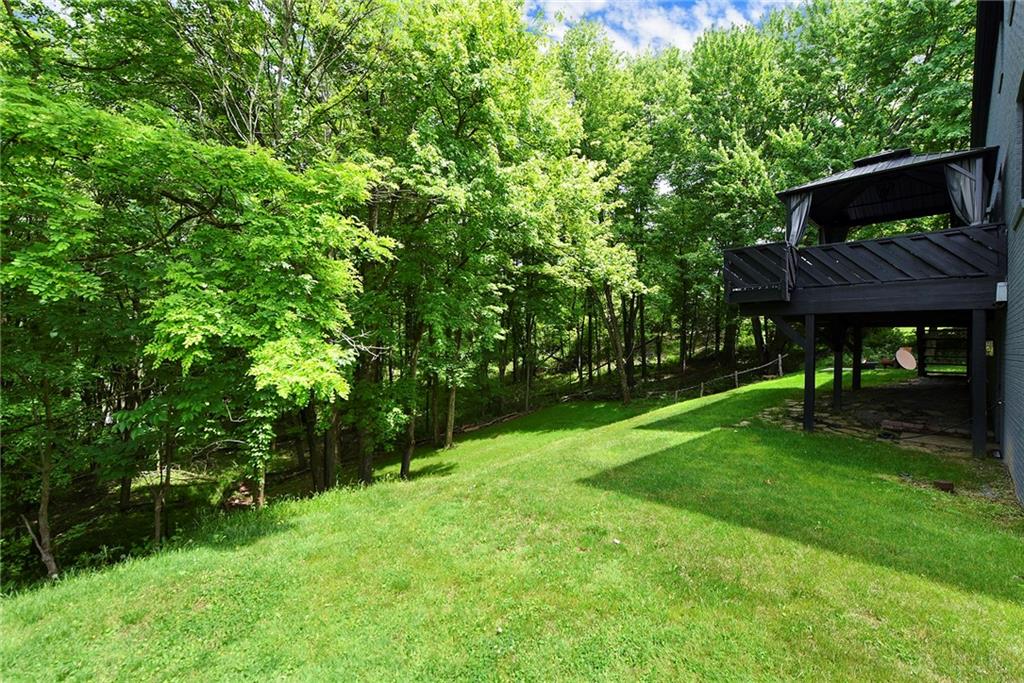 7018 Franklin Road Seven Fields, PA 16046 - Photo 41 of 48 a view of a backyard with table and chairs and potted plants and large trees