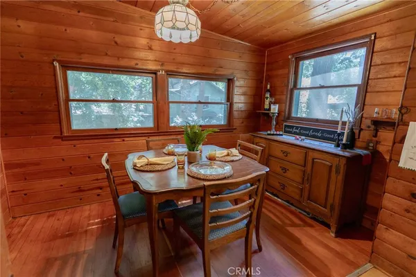 a view of a dining room with furniture a chandelier and wooden floor