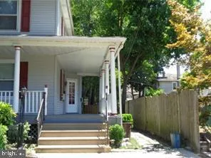a view of a house with plants and large tree