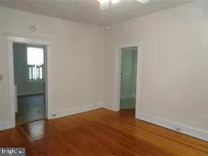 an empty room with wooden floor and closet