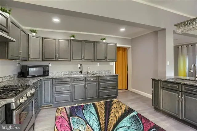 a kitchen with kitchen island granite countertop a sink cabinets and stainless steel appliances