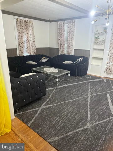 a living room with furniture a large window and dresser